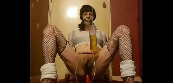  crossdressing sissy rides a dildo while drinking his own piss